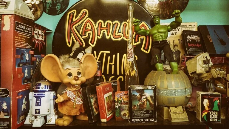 Vintage shelf with retro toys including Hulk, R2-D2, and classic 80s memorabilia