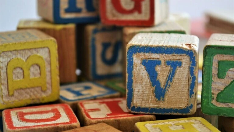 Vintage wooden alphabet blocks with faded colors and worn letters