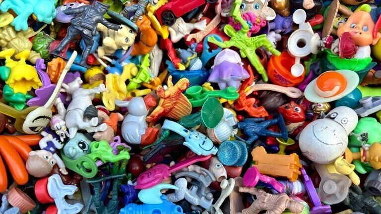 Šarena kolekcija malih retro igračaka iz 80-ih i 90-ih godina – figure, autići, životinje i likovi iz Kinder jaja.