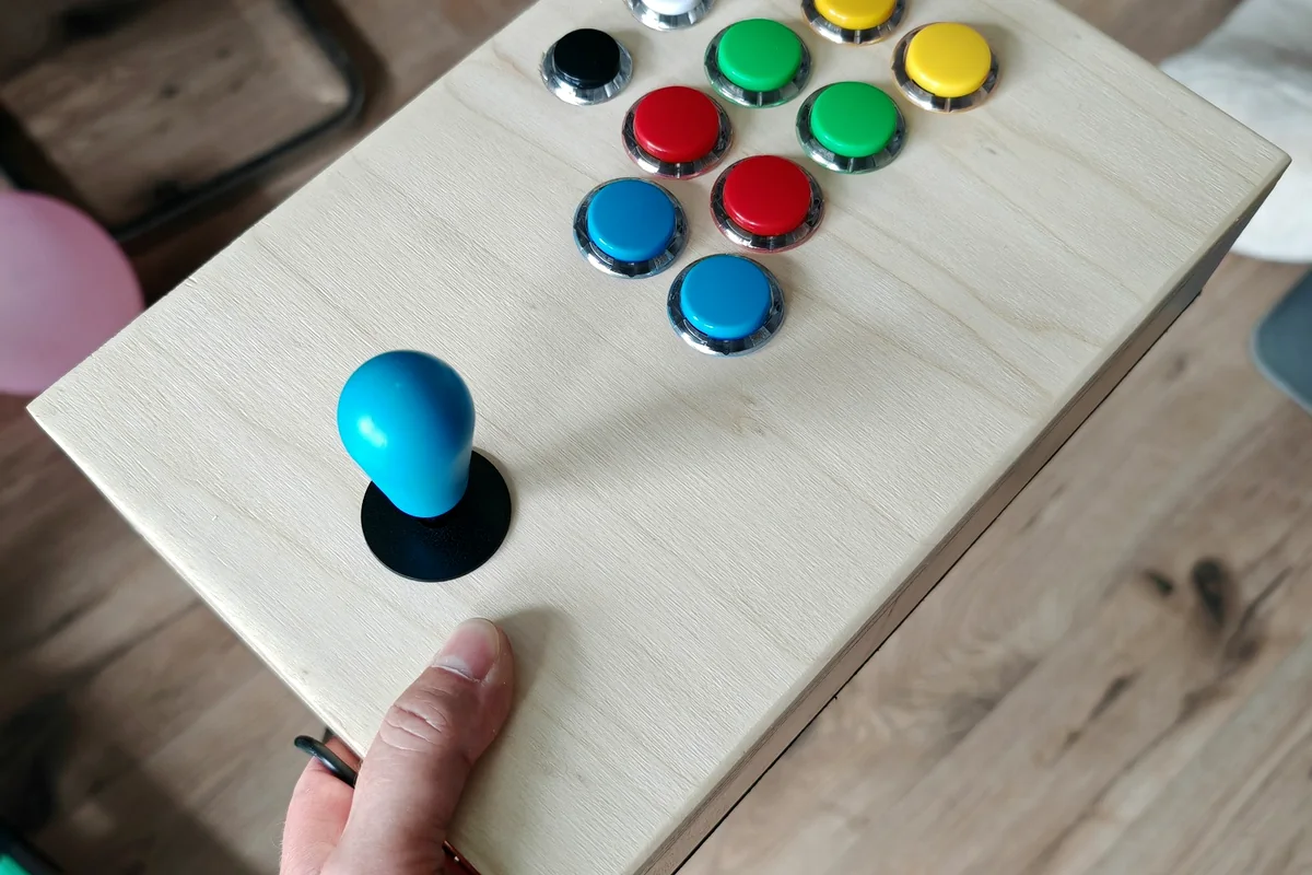 Handmade retro arcade joystick held in one hand to show its size