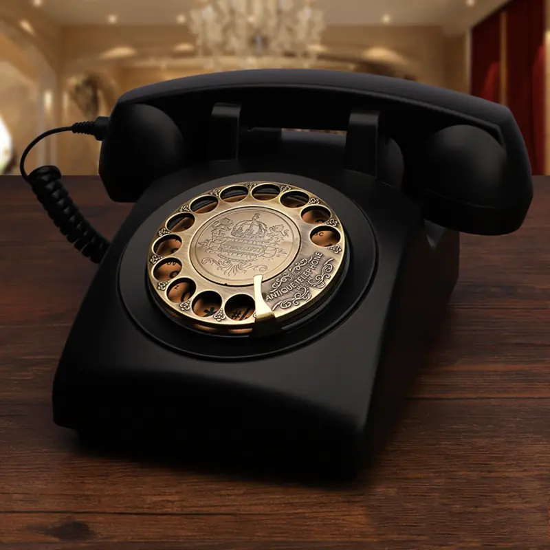 Crni starinski telefon sa bronzanim brojčanikom