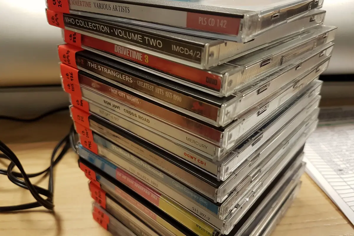 A stacked collection of music CDs in jewel cases