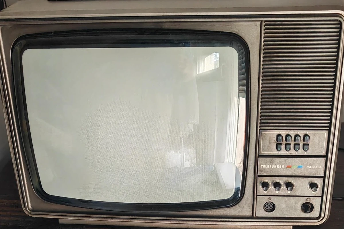 Stari Telefunken CRT televizor sa zaobljenim staklenim ekranom, dugmićima za kanale i komandama na prednjoj strani