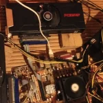 Bitcoin mining rig from 2013 with two PowerColor Radeon HD 7870 MYST graphics cards on a woven reed table.