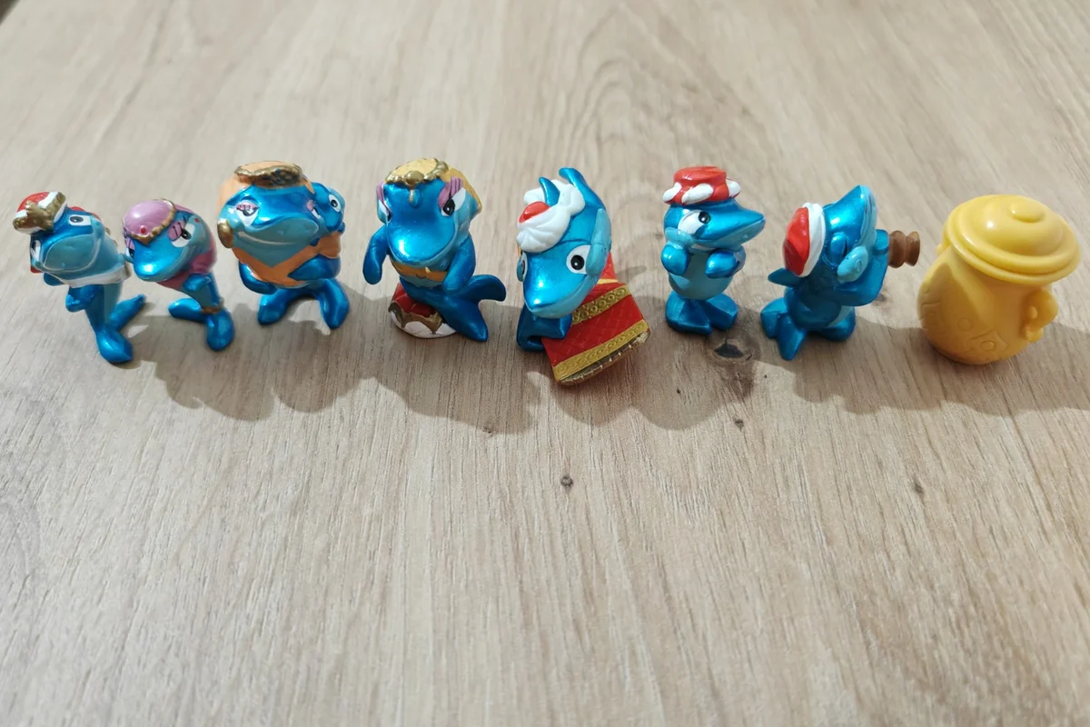 Blue Kinder figures from the Squalibabà shark series, with turbans and a flying carpet beside a separate yellow accessory