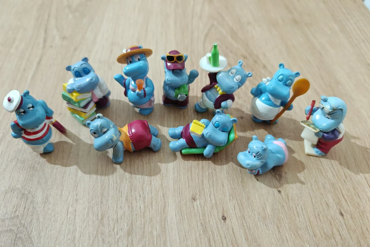 Blue Kinder Happy Hippos figures with a cooking spoon, books, a serving tray and a deckchair